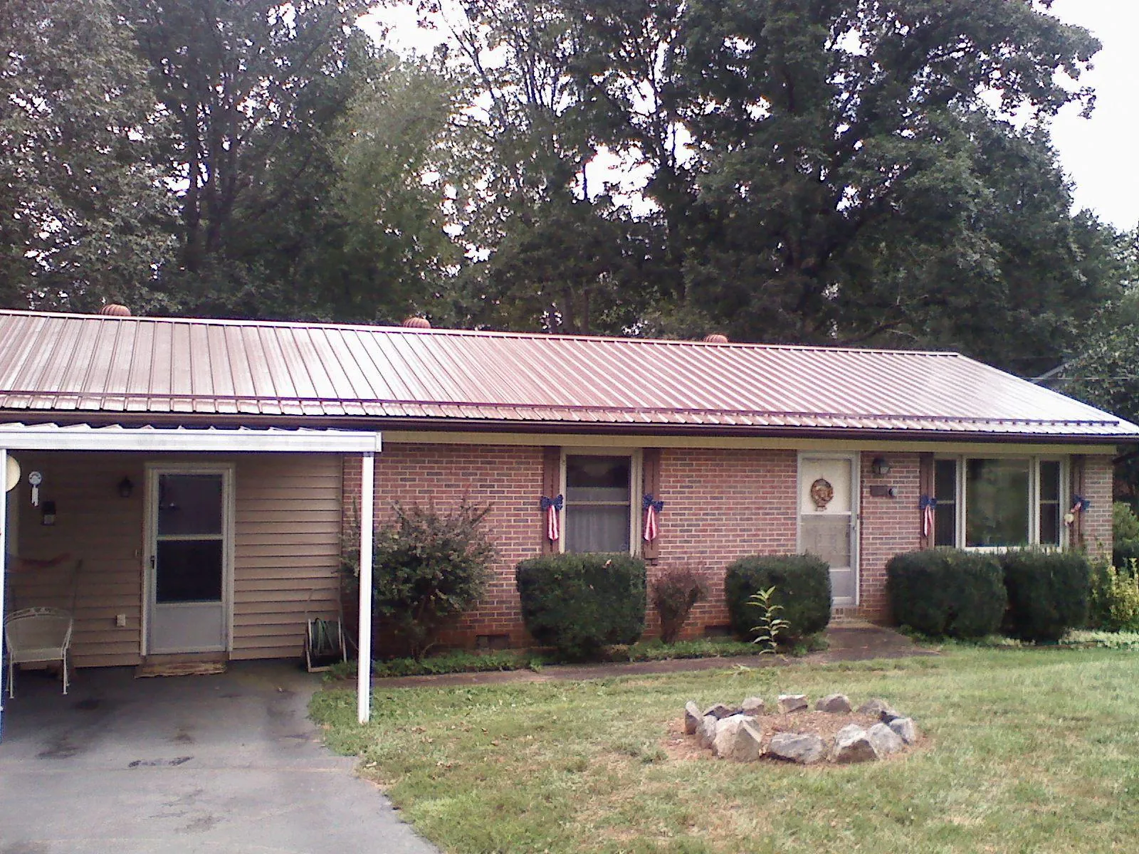 Bronze metal roof and carport on a brick ranch home — Roof Repair work by our crew in Sparr